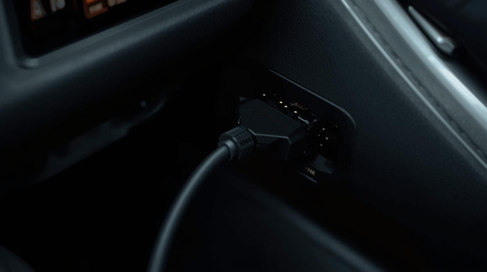Cable diagnostico OBD2 conectado firmemente al puerto de diagnostico ubicado debajo del tablero vehiculo