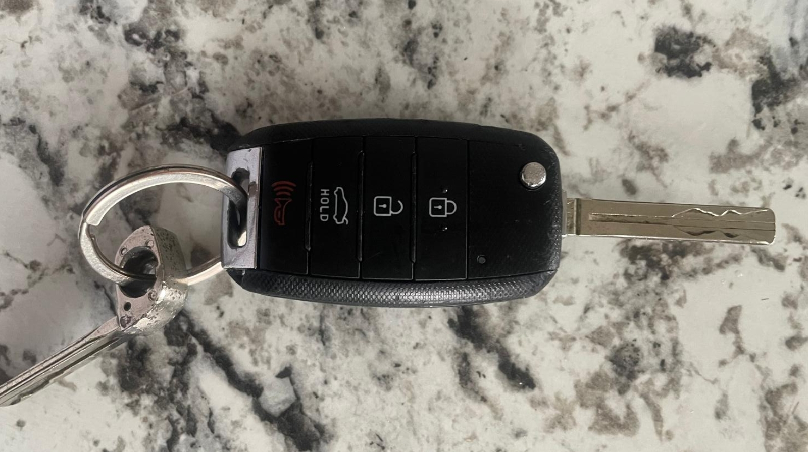 Beeper con blade plegable sobre superficie de mármol