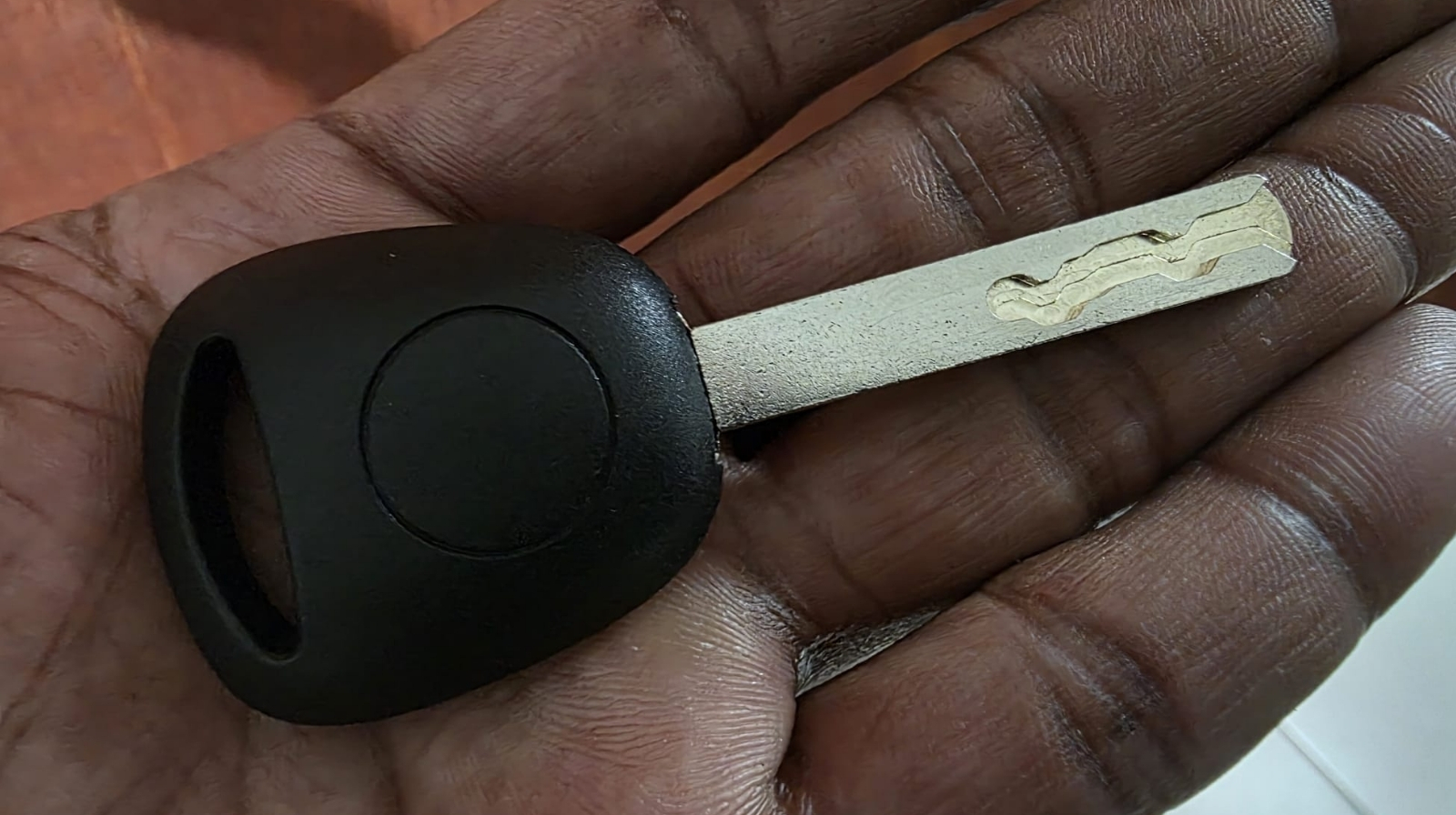 Llave High Security con chip para carro sostenida en la mano